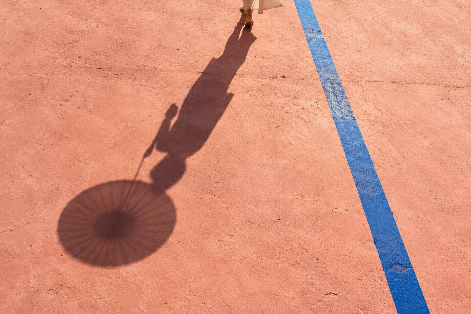 A person becomes a shadow. A street becomes a composition.